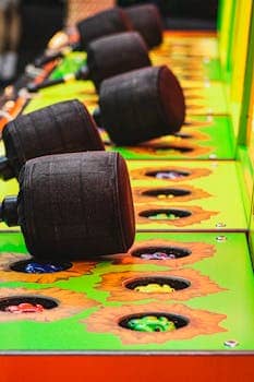 Close-up of a vibrant Whack-a-Mole arcade game with mallets and colorful moles.